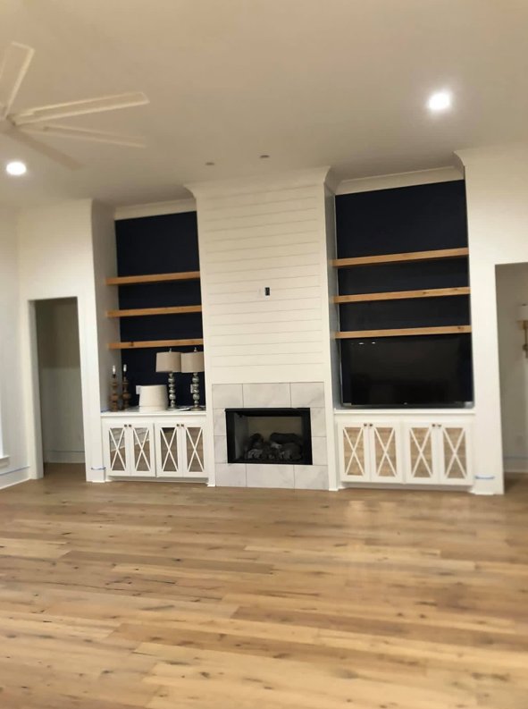 Custom living room with shiplap fireplace and built-ins by J.V. Construction