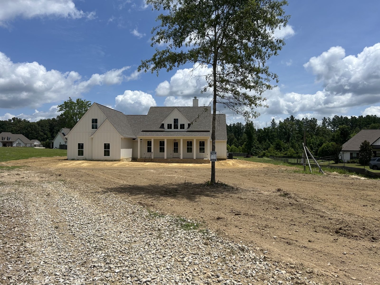 Custom white farmhouse with a covered front porch built by J.V. Construction