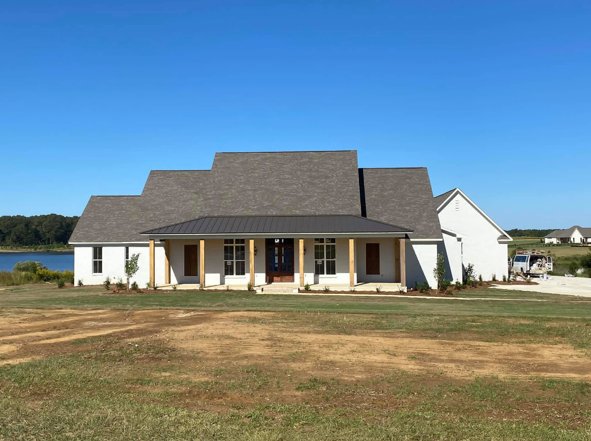 Completed custom farmhouse overlooking the water, built by J.V. Construction
